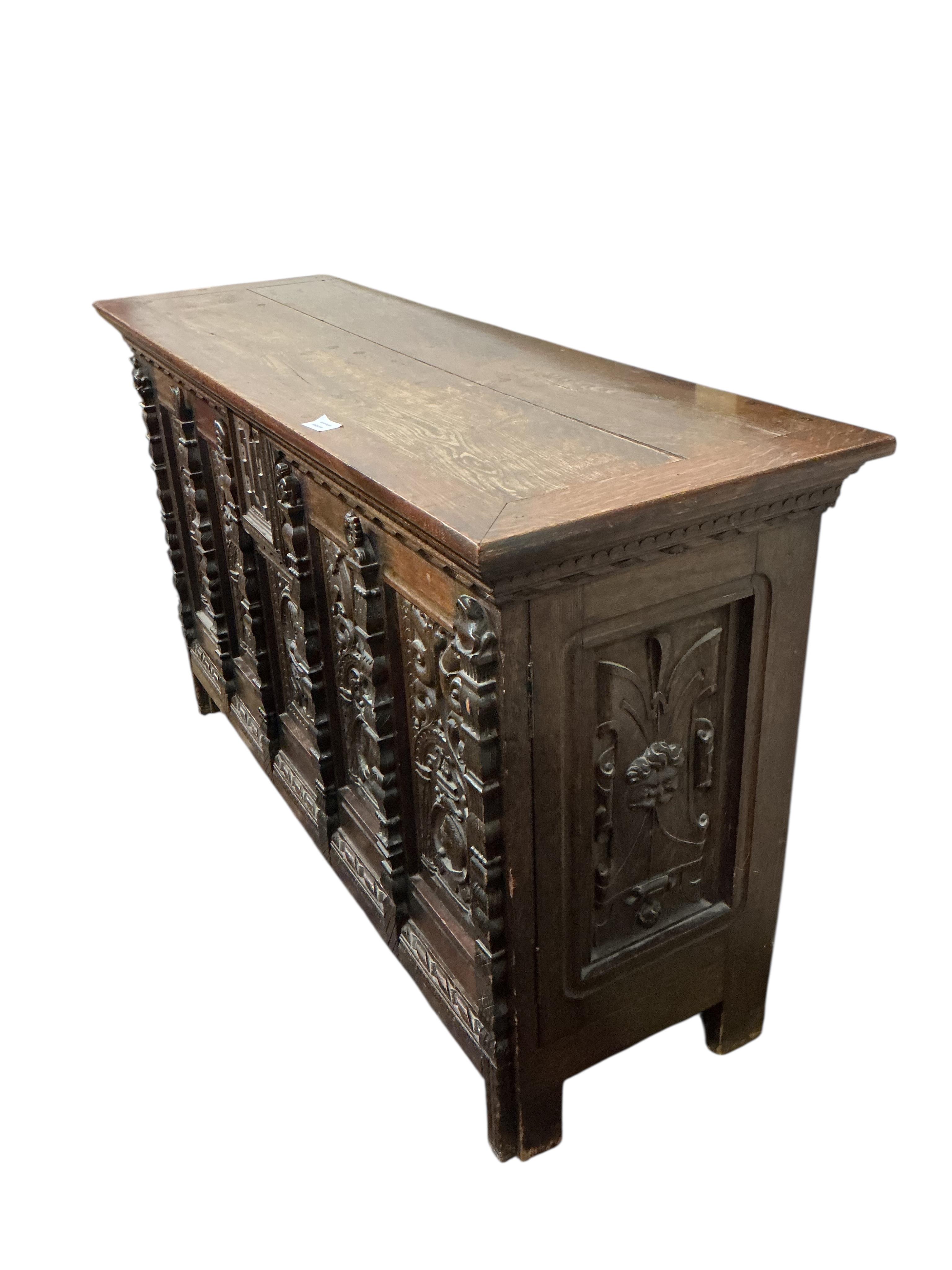 A 17th century style carved oak side coffer, width 145cm, depth 47cm, height 86cm